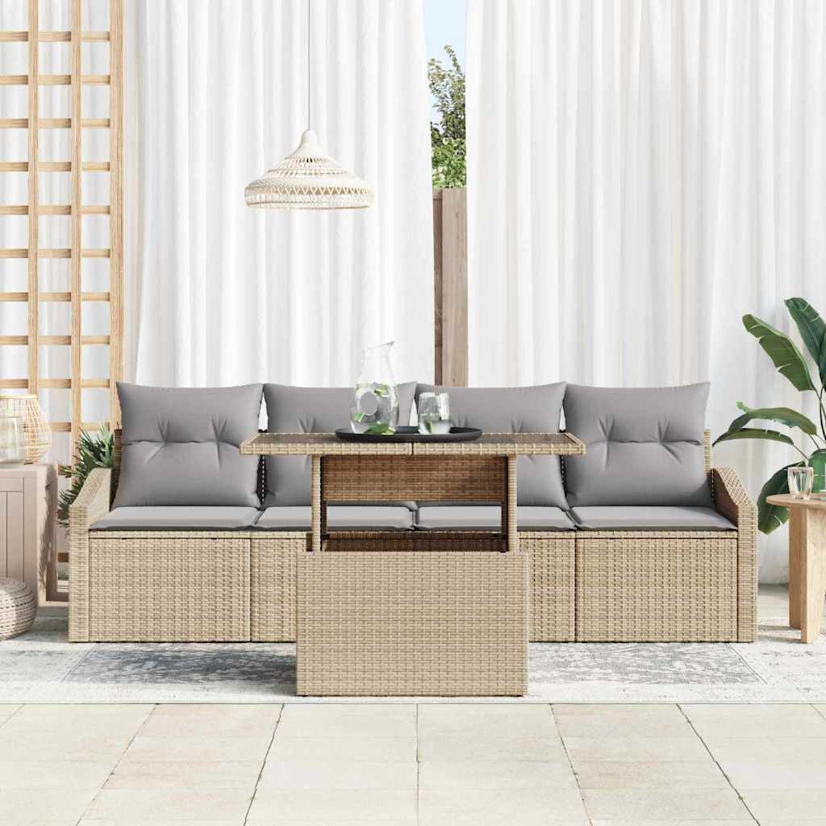 Outdoor-Sitzbereich mit beigen Rattanmöbeln, grauen Kissen und einem Tisch. Weiße Vorhänge und eine Pendelleuchte im Hintergrund.
