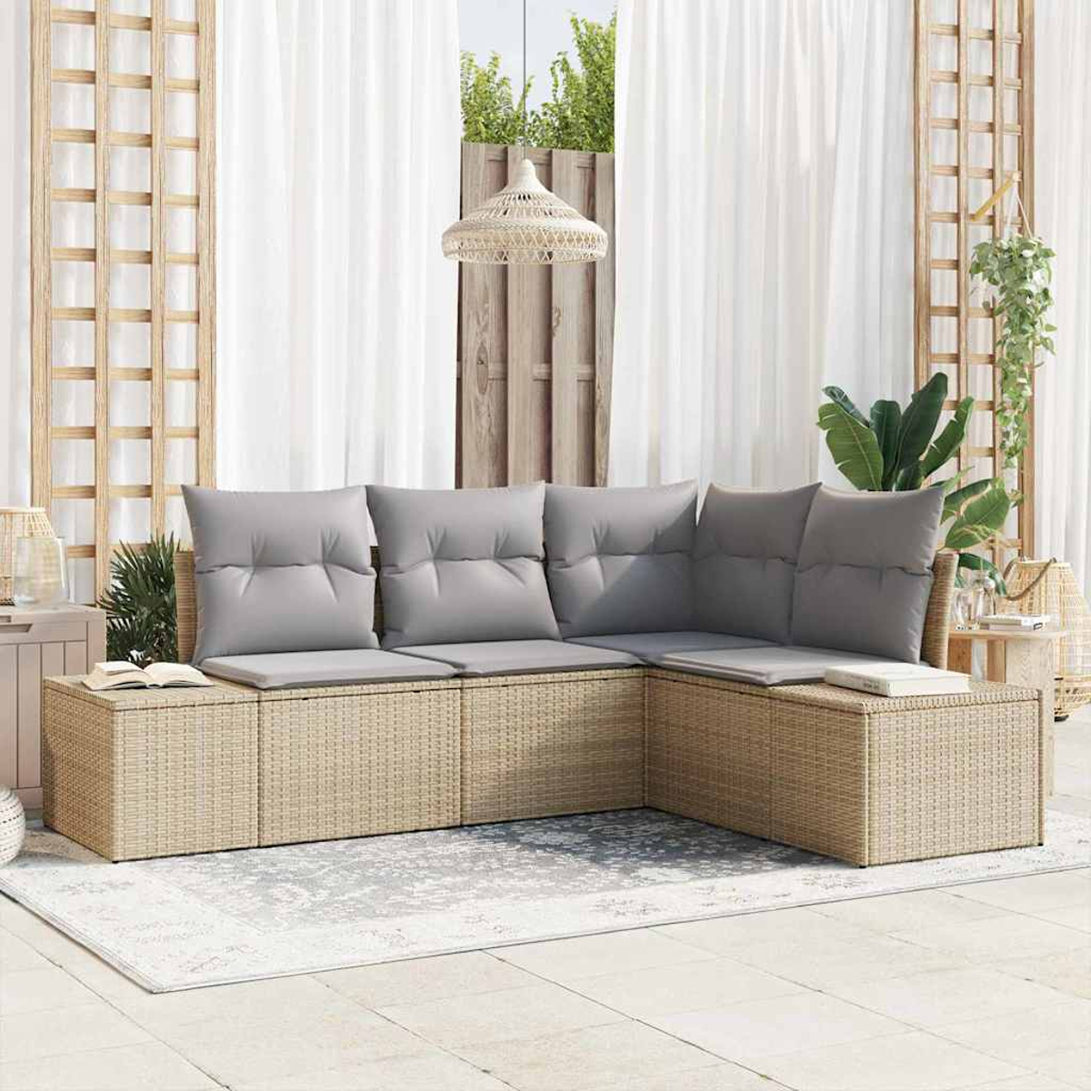 Geflochtenes Ecksofa mit grauen Kissen auf einer Terrasse. Weiße Vorhänge und eine Hängelampe im Hintergrund.