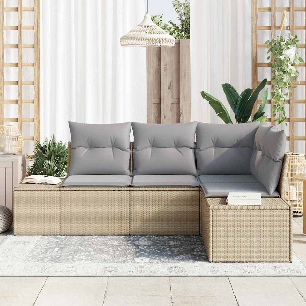 Geflochtenes Sofa mit grauen Kissen auf einem gemusterten Teppich, in der Nähe eines Fensters mit weißen Vorhängen und Pflanzen.