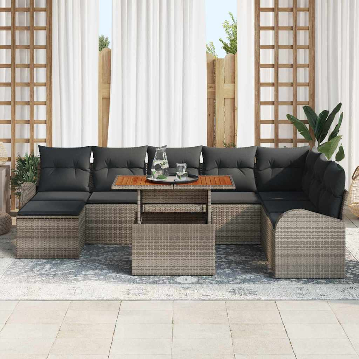 Outdoor-Ecksofa mit grauen Kissen und einem Holztisch. Weiße Vorhänge und ein Garten im Hintergrund. Eine Wasserkaraffe auf dem Tisch.