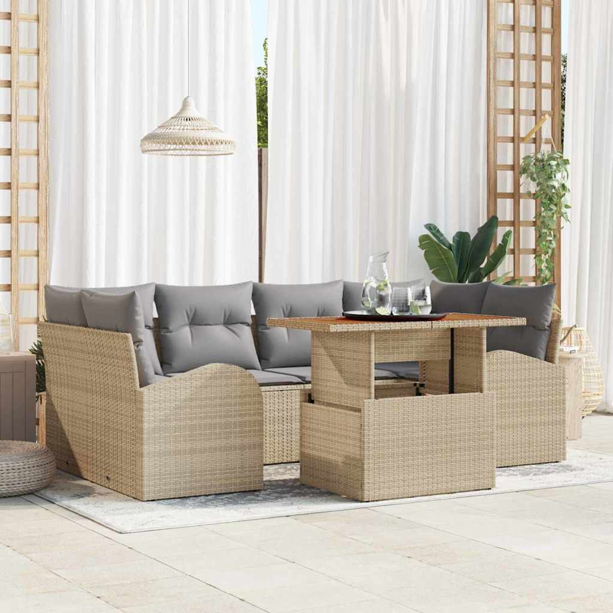 Terrassenset mit Wicker-Sofa, grauen Kissen, Lifttisch und weißen Vorhängen. Eine Hängelampe und Grünzeug ergänzen die Szene.