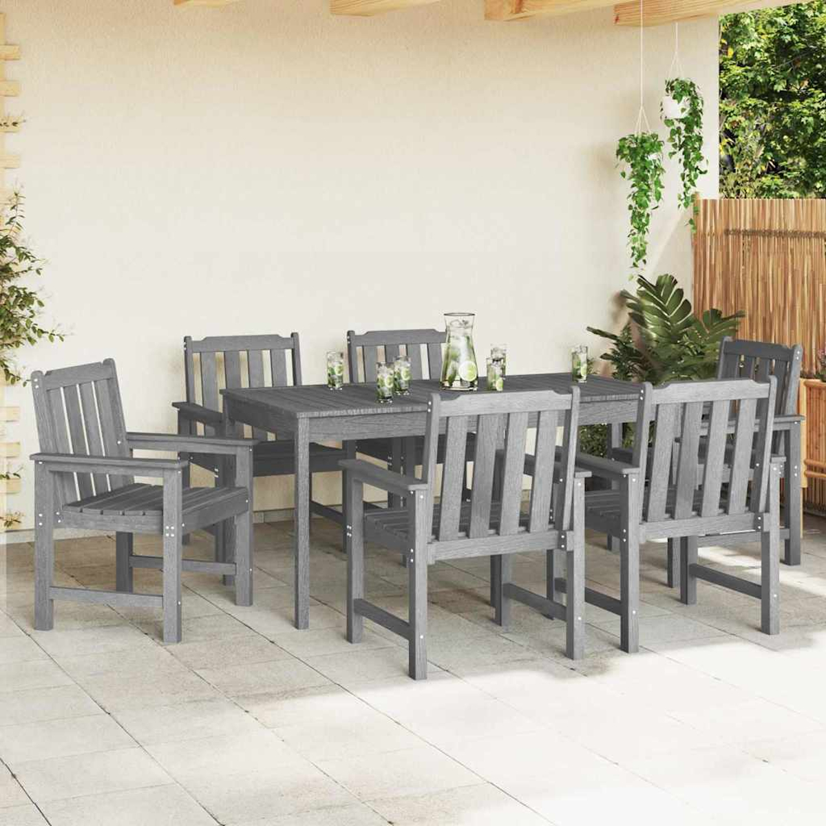 Ein graues Esszimmer-Set für den Außenbereich mit sechs Stühlen und einem Tisch, Getränken auf dem Tisch sowie einer Terrasse mit Pflanzen und einem Bambuszaun.