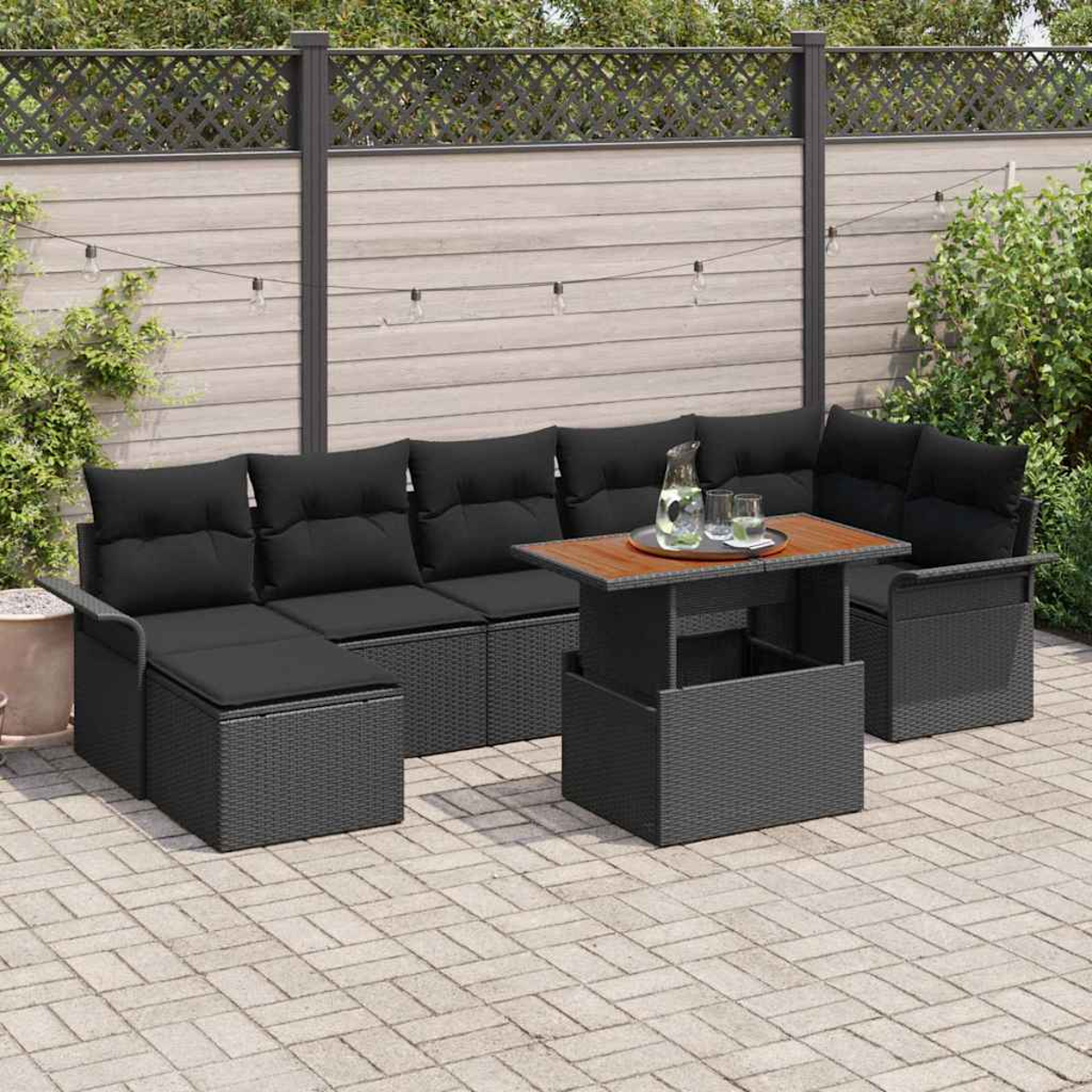 Outdoor-Patio-Set mit schwarzen Kissen und einem Tisch mit Holzplatte auf einer Backsteinterrasse.