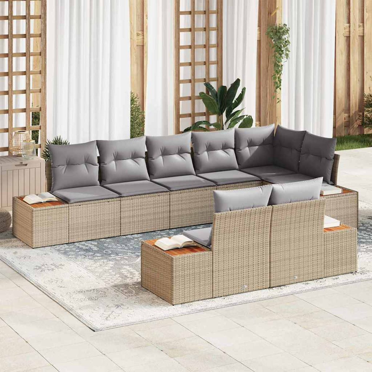 Ein Ecksofa im Freien mit grauen Kissen steht auf einem gemusterten Teppich. Ein Beistelltisch aus Holz und ein Holzspalier befinden sich im Hintergrund.