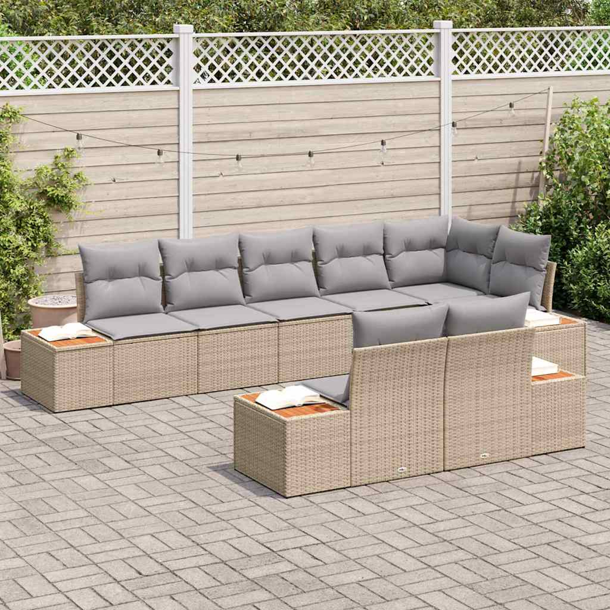 Outdoor-Ecksofa mit grauen Kissen und gewebtem beigen Rahmen. Holzbeistelltische mit Büchern. Auf einer Ziegelterrasse mit weißem Zaun.