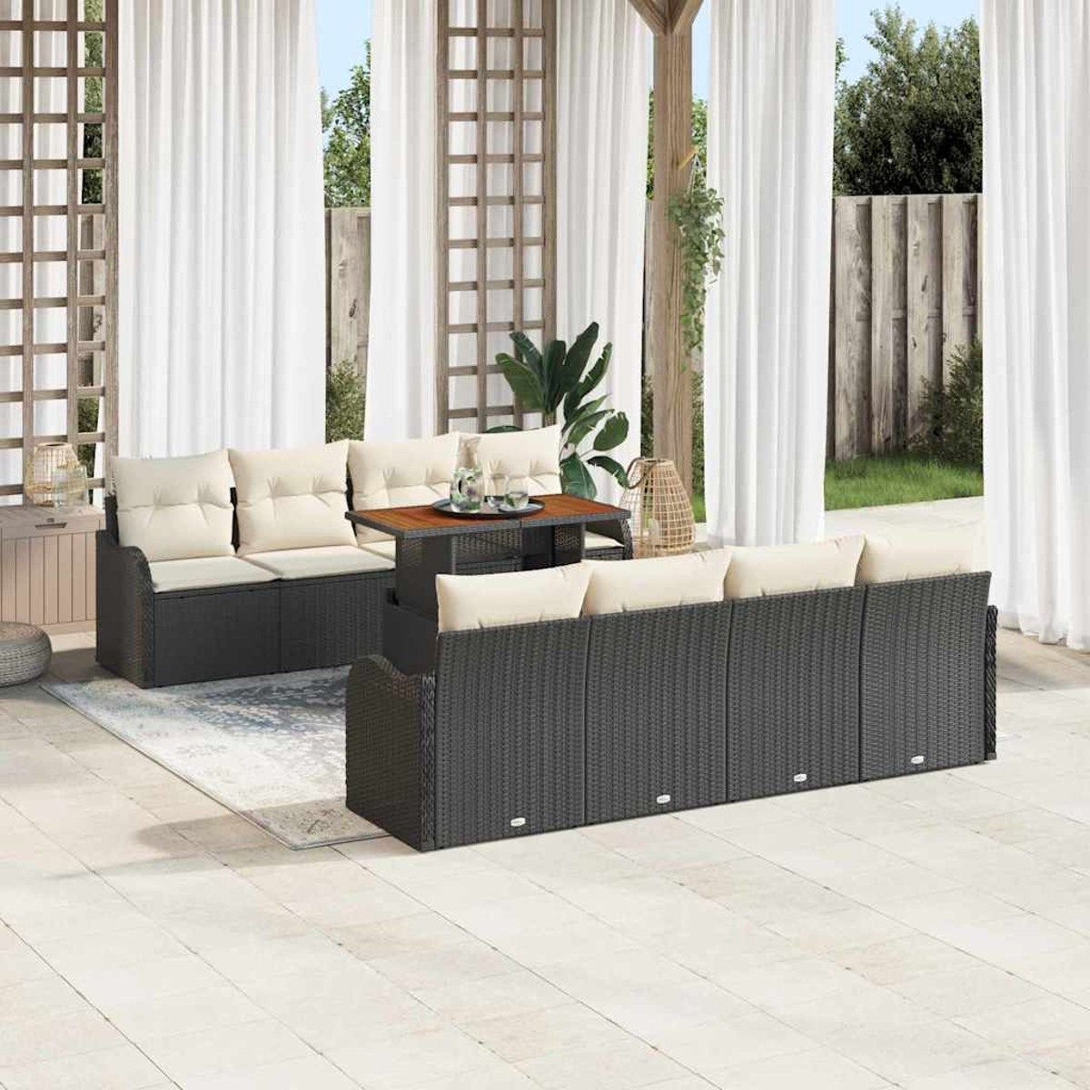 Terrassenset mit Korbmöbeln, beigen Kissen und einem Holztisch. Weiße Vorhänge und ein Gartenhintergrund schaffen eine entspannte Atmosphäre.