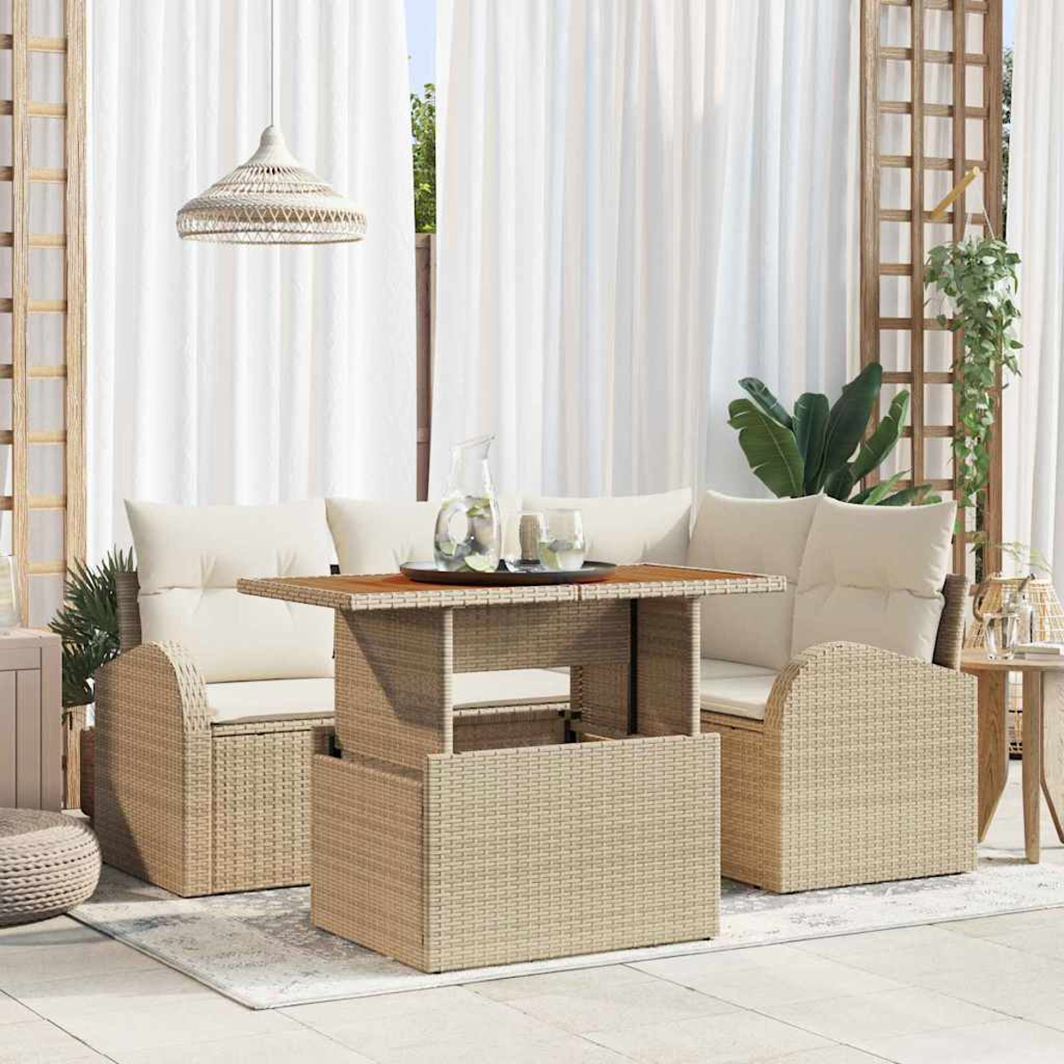 Juego de patio al aire libre con mesa, dos sillas y un sofá. Una jarra y vasos sobre la mesa. Cortinas blancas y una lámpara colgante.