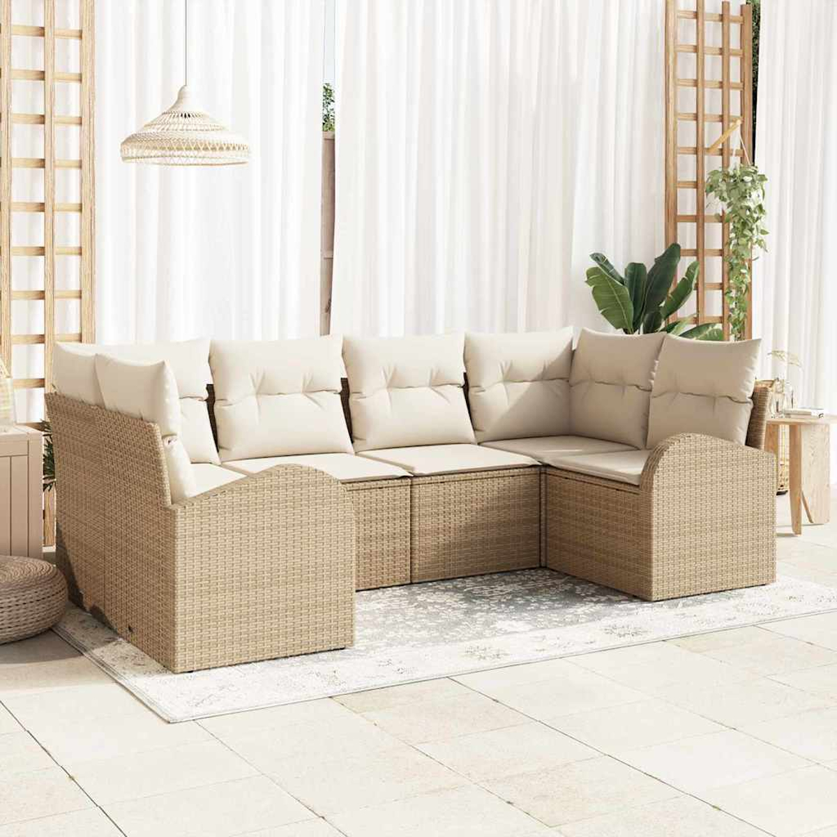 Outdoor-Ecksofa mit beigen Kissen. Geflochtener Rahmen. Auf einer Terrasse mit Teppich und weißen Vorhängen im Hintergrund.