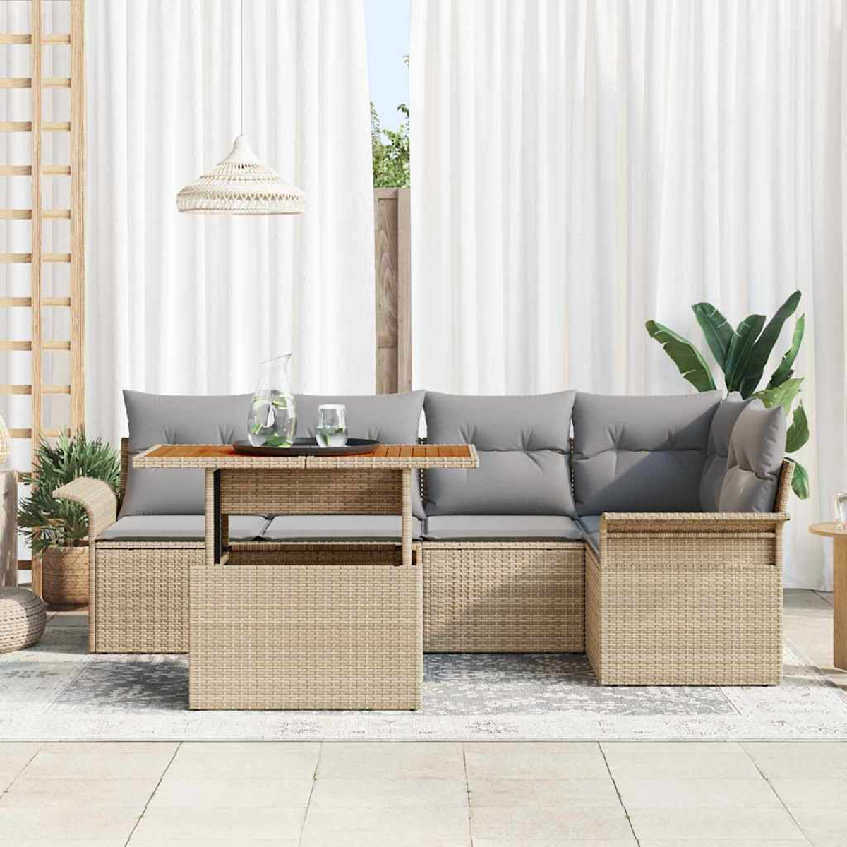 Gartenmöbel-Set für die Terrasse. Umfasst ein geflochtenes Sofa mit grauen Kissen, einen Tisch mit Holzplatte und weiße Vorhänge im Hintergrund.