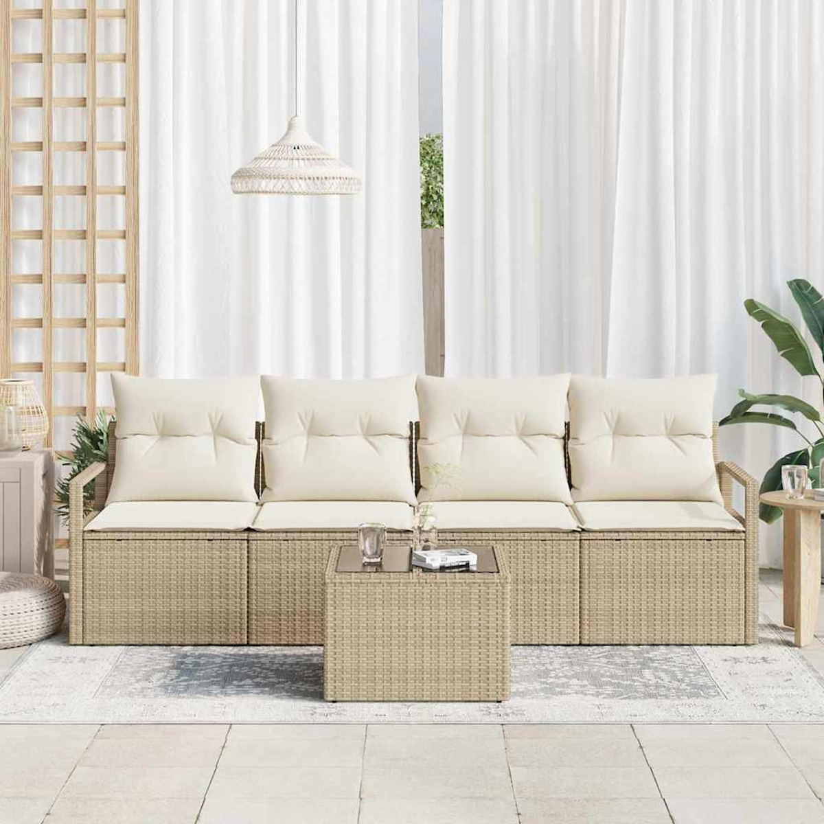 Ein beiges Outdoor-Sofa aus Korbgeflecht mit cremefarbenen Kissen, einem passenden Tisch, einem Teppich und weißen Vorhängen im Hintergrund.