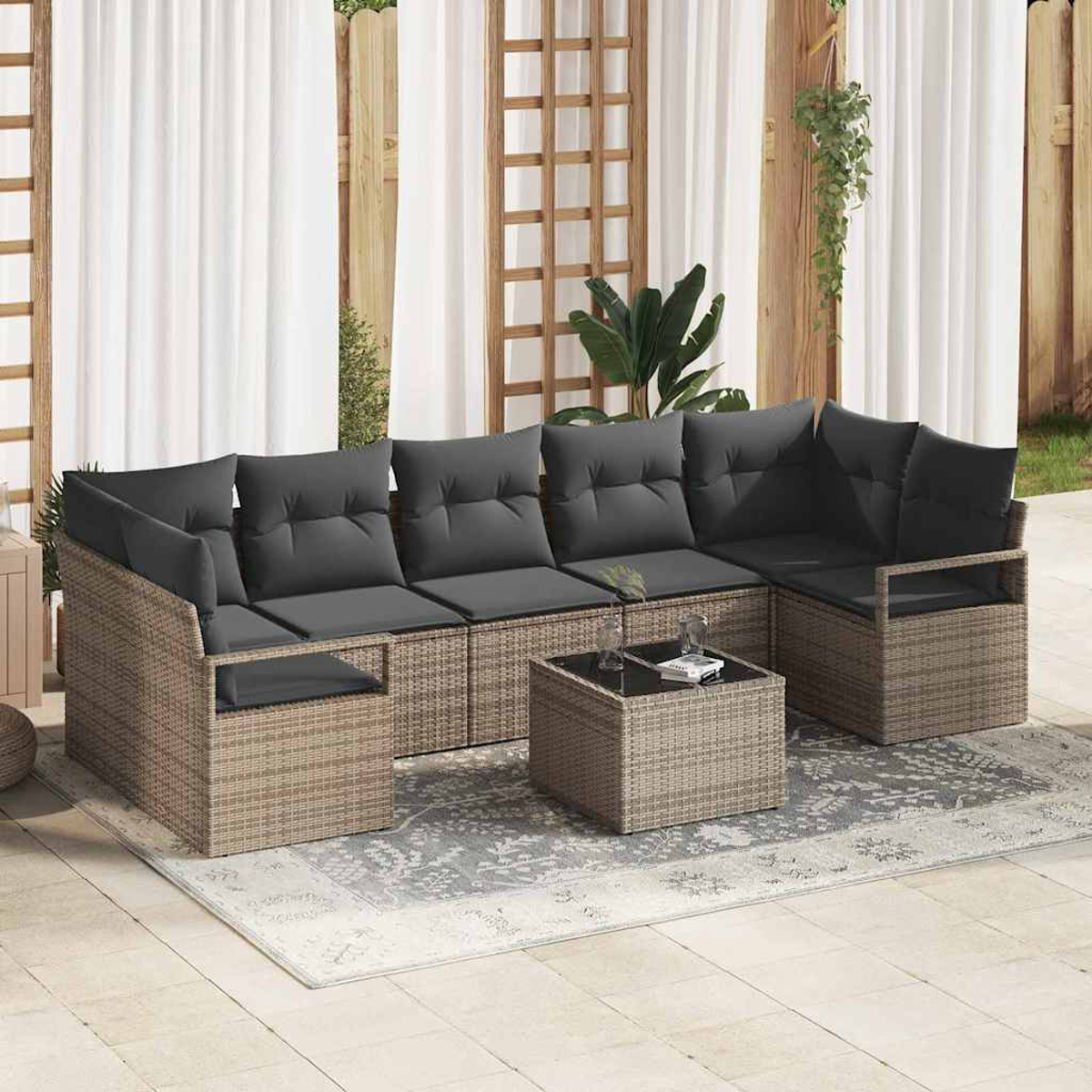 Ecksofa im Freien mit grauen Kissen und einem Couchtisch auf einem gemusterten Teppich. Der Hintergrund zeigt weiße Vorhänge und Holzgitter.