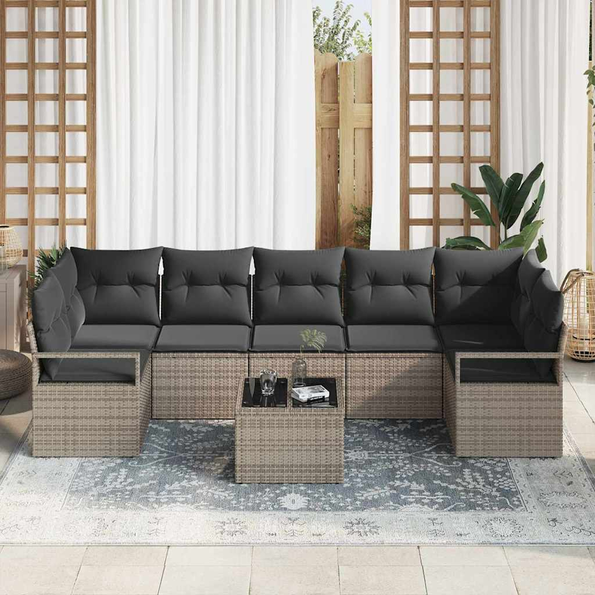 Outdoor-Sitzgruppe mit grauen Kissen auf einem grauen Teppich. Enthält einen Tisch mit Glasplatte. Weiße Vorhänge und Holzrahmen.