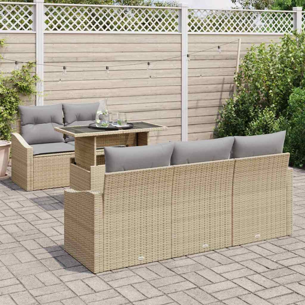 Gartenmöbel-Set aus Korbgeflecht auf einer Terrasse, mit Sofa, Liebesitz und Tisch. Im Hintergrund ein Zaun und Grün.