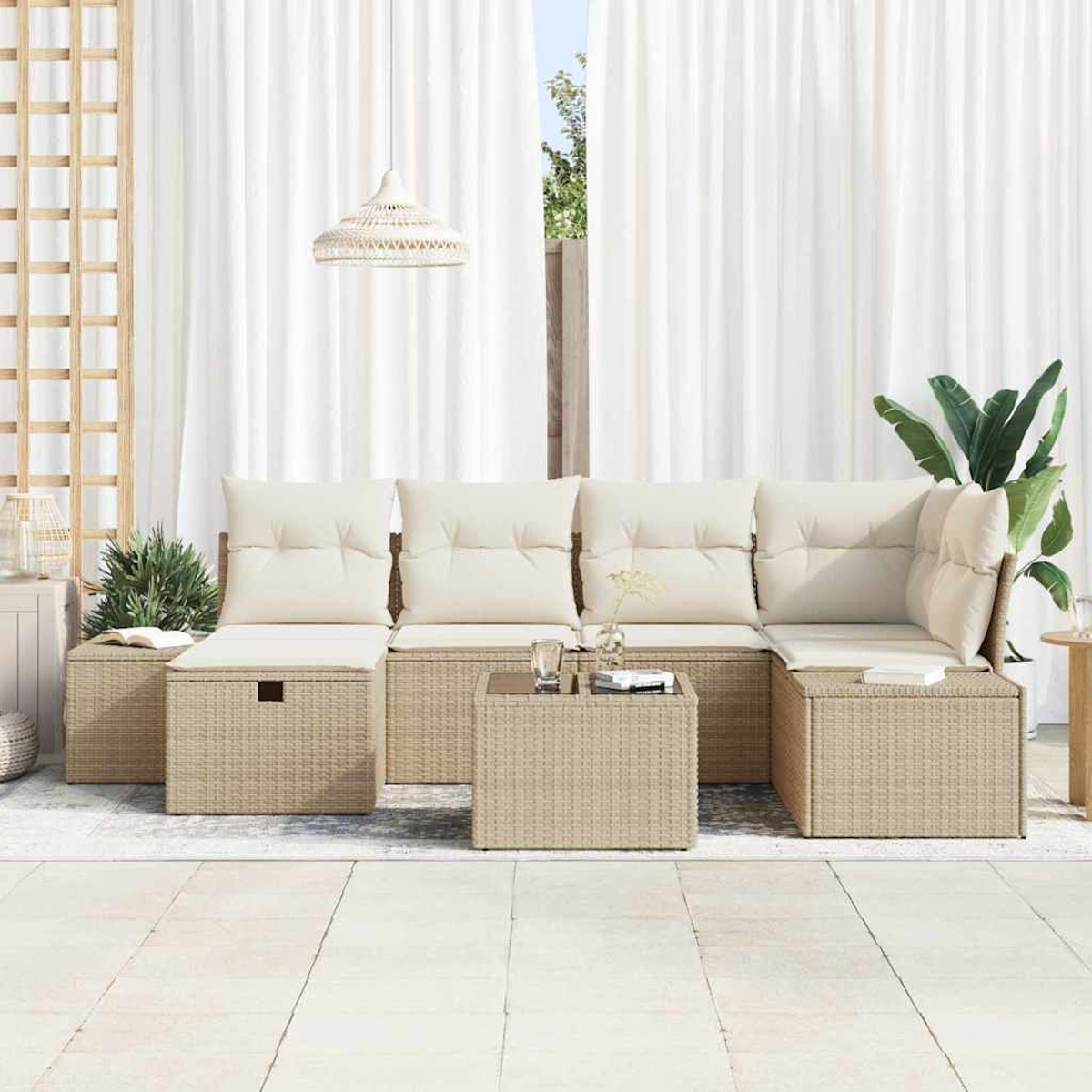 Outdoor-Ecksofa mit cremefarbenen Kissen, Korbtischen, weißen Vorhängen und einer Hängelampe. Pflanzen sorgen für Grün. Heller, luftiger Raum.