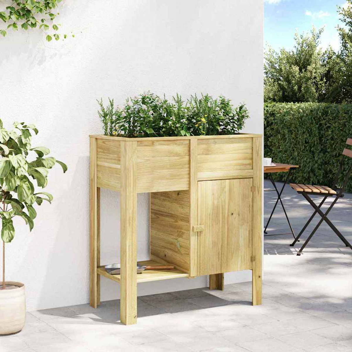 Fioriera in legno con piante. Porta a destra, ripiano sotto. Tavolo e sedia sullo sfondo. Muro bianco.