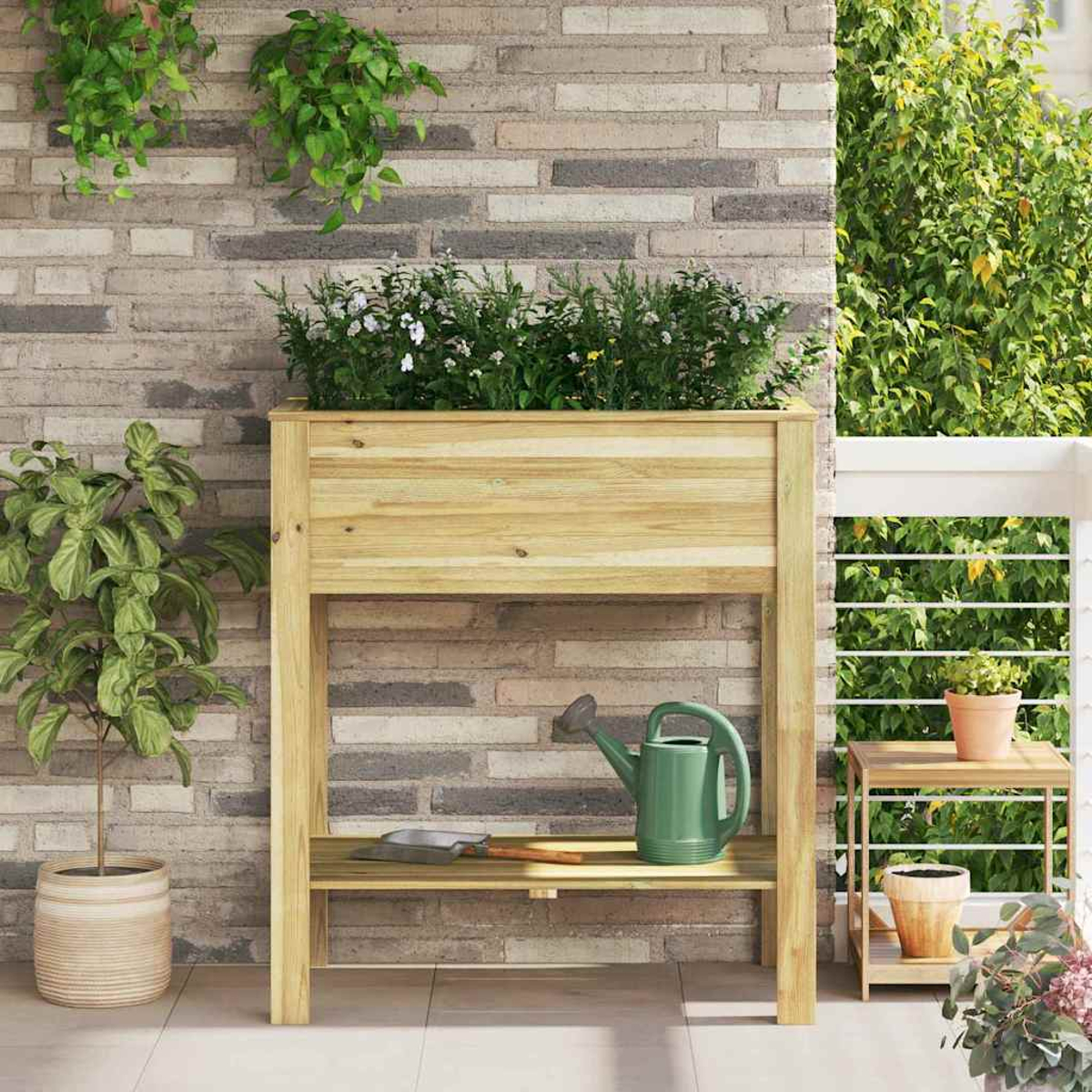 Fioriera in legno con piante. Un annaffiatoio, una cazzuola e un tavolino con piante e un muro di mattoni sullo sfondo.