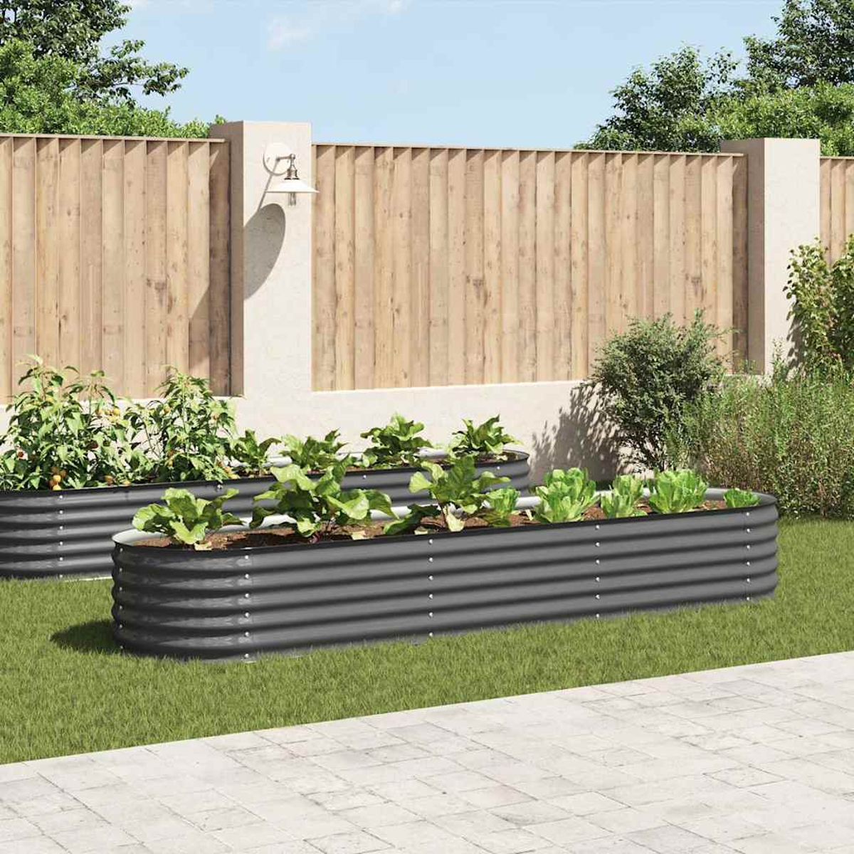 Zwei erhöhte Gartenbeete mit grünen Pflanzen. Ein Holzzaun und grünes Gras im Hintergrund.
