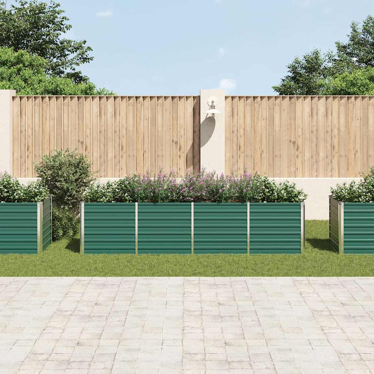 Grüne Metallpflanzkästen mit Blumen stehen vor einem Holzzaun. Im Vordergrund eine Beton-Terrasse, im Hintergrund blauer Himmel.