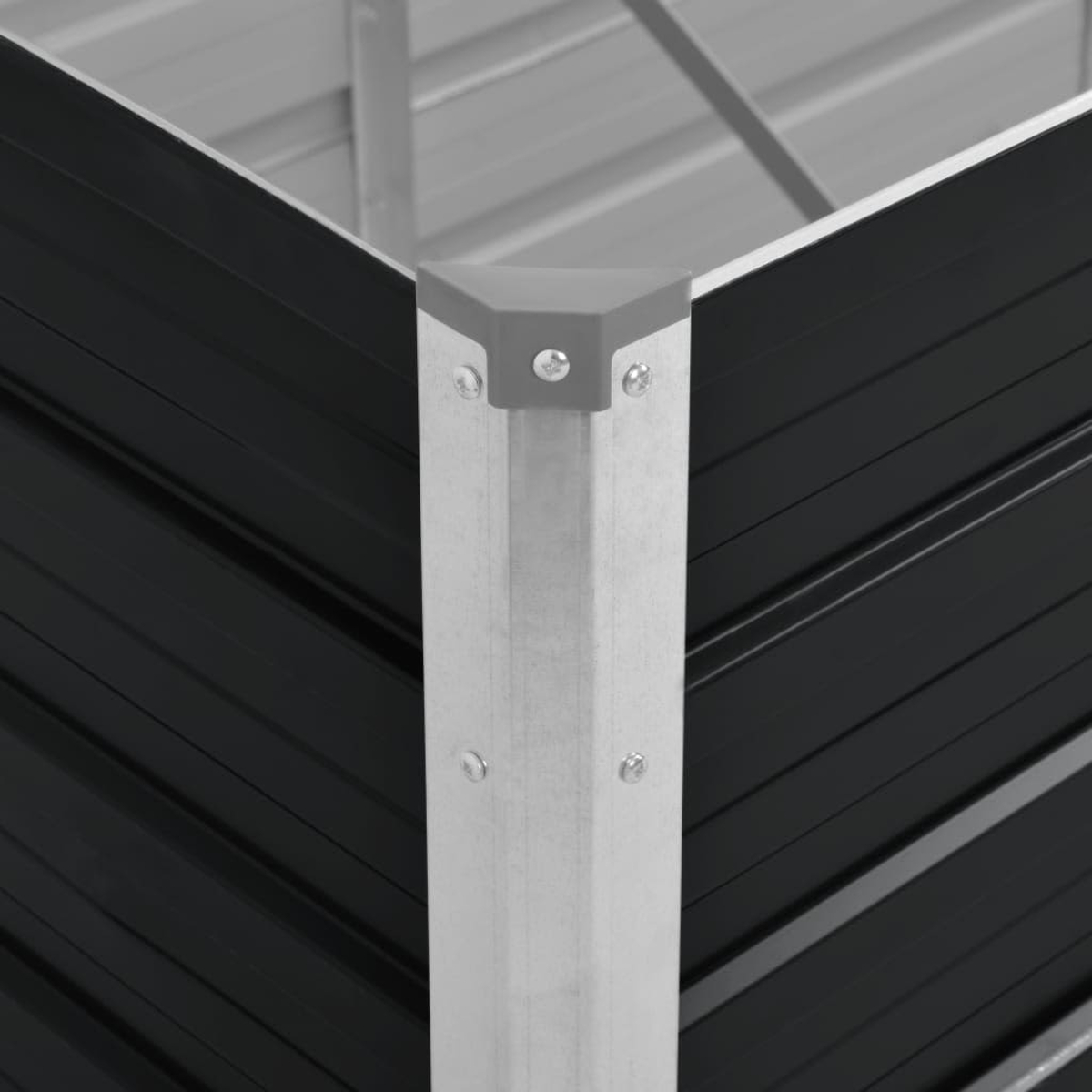 Nahaufnahme einer Metallecke des Gartenbeets. Schwarze, gewellte Seiten, silberner Eckpfosten, graue Oberkante und graue Eckkappe.