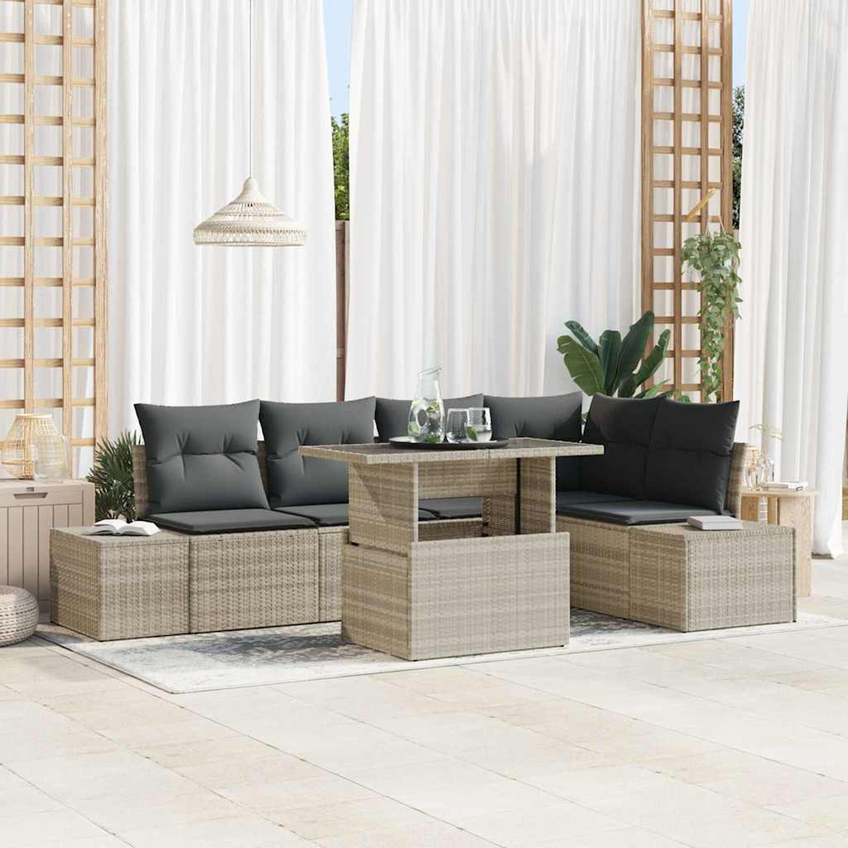Garten-Terrassenset mit grauen Kissen, Korbmöbeln und einem Tisch mit Gläsern. Weiße Vorhänge im Hintergrund.