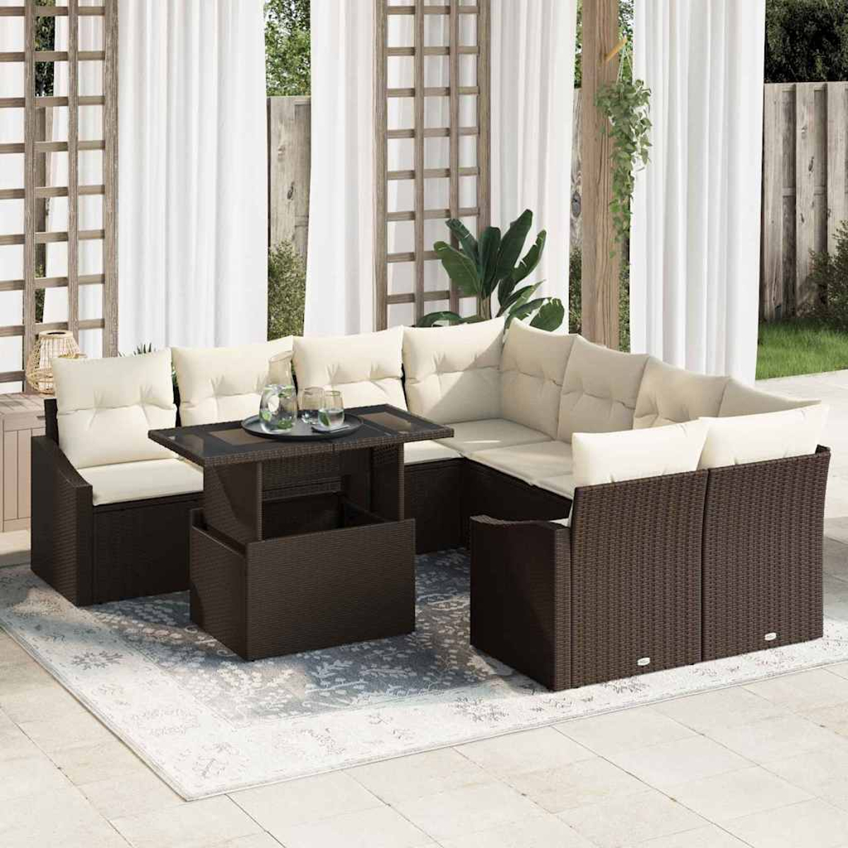 Outdoor-Ecksofa mit beigefarbenen Kissen und einem hochklappbaren Couchtisch auf einem gemusterten Teppich, auf einer Terrasse. Weiße Vorhänge im Hintergrund.