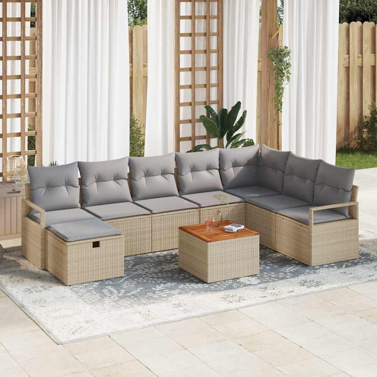 Outdoor-Ecksofa mit grauen Kissen und einem Holztisch auf einem gemusterten Teppich. Weiße Vorhänge und Holzzaun im Hintergrund.