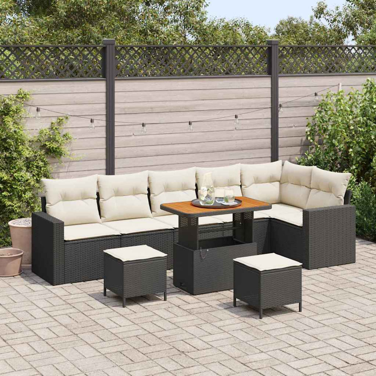 Gartenmöbel-Set mit Ecksofa, zwei Hockern und einem Tisch. Die Szene ist ein Hinterhof mit Zaun.