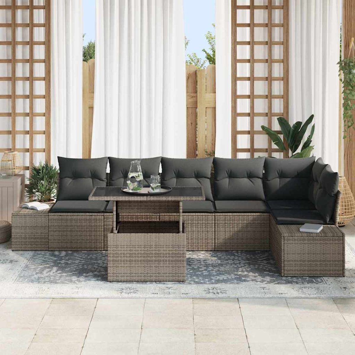 Outdoor-Ecksofa mit grauen Kissen und Couchtisch. Weiße Vorhänge und Holzgitter im Hintergrund.