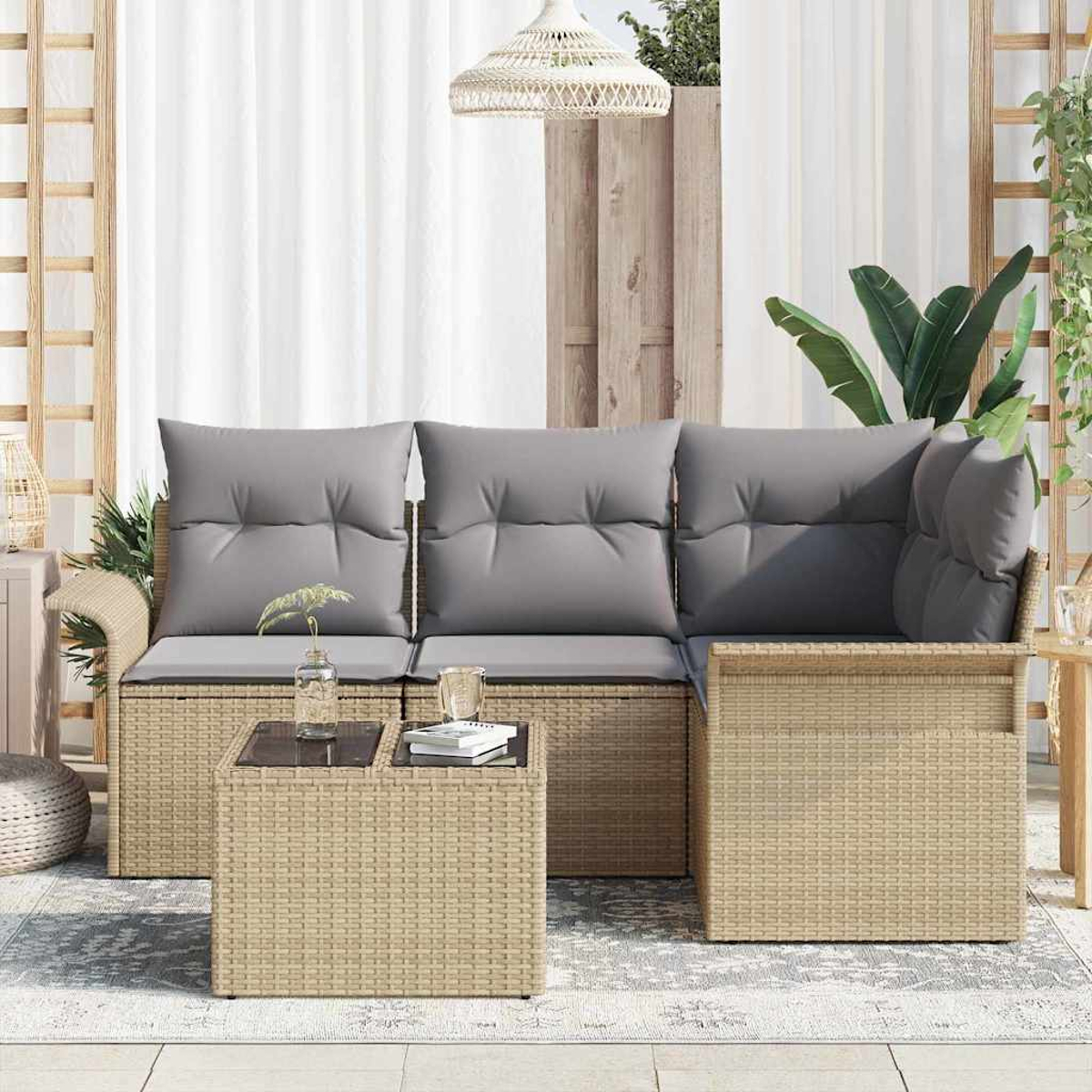 Outdoor-Korbsessel mit grauen Kissen und einem kleinen Tisch. Eine Lampe hängt darüber und Pflanzen sind im Hintergrund.