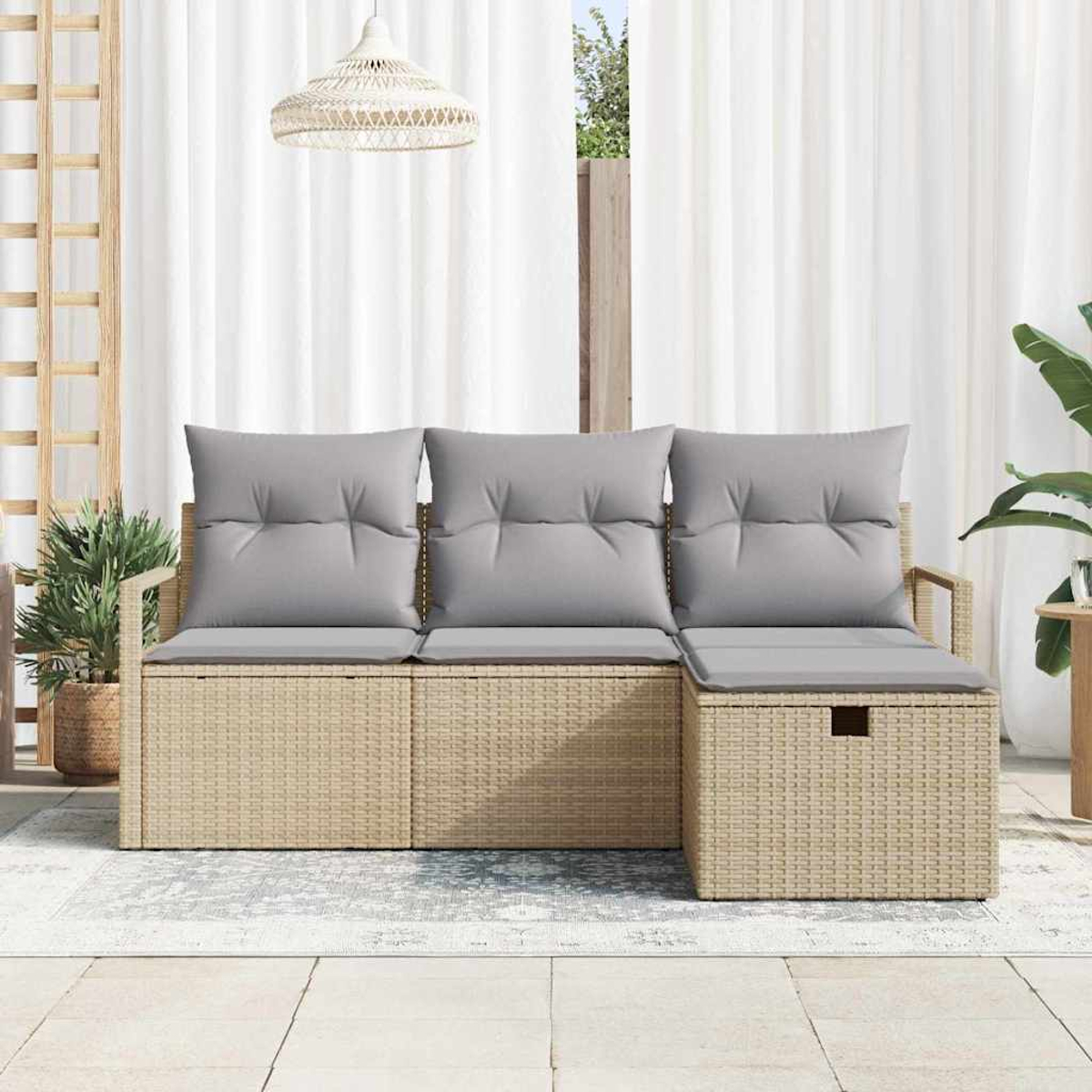 Un sofá de ratán para exteriores con cojines grises está en un patio. Cortinas blancas y plantas están en el fondo, con una lámpara colgante.