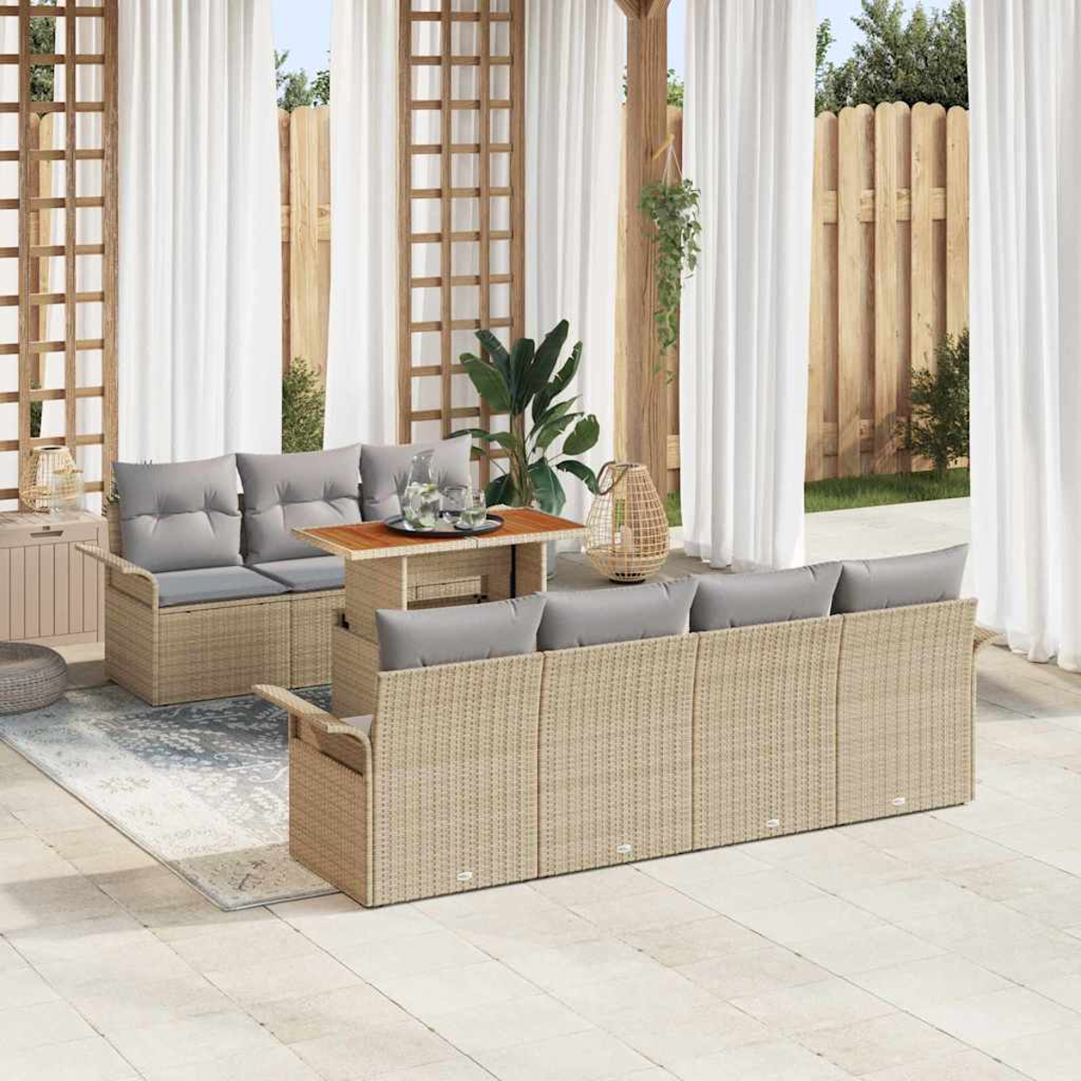 Terrasse mit beigen Korbmöbeln, grauen Kissen und Holztisch. Weiße Vorhänge und Holzzaun im Hintergrund.
