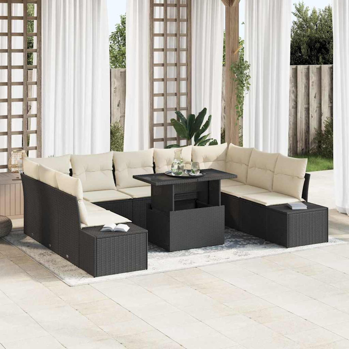 Outdoor-Sitzgruppe mit beigen Kissen und schwarzen Rattanrahmen, um einen schwarzen Tisch herum. Weiße Vorhänge und ein Holzgitter im Hintergrund.