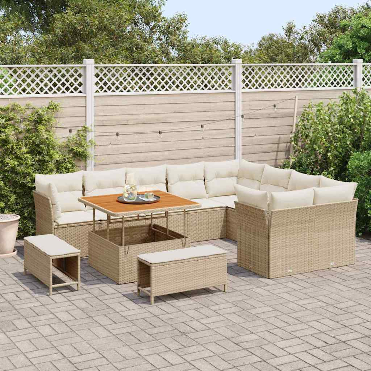 Garten-Sitzgruppe auf einer Terrasse. Enthält ein Ecksofa, einen Couchtisch und zwei Bänke, alle in Beige. Im Hintergrund ein weißer Zaun.