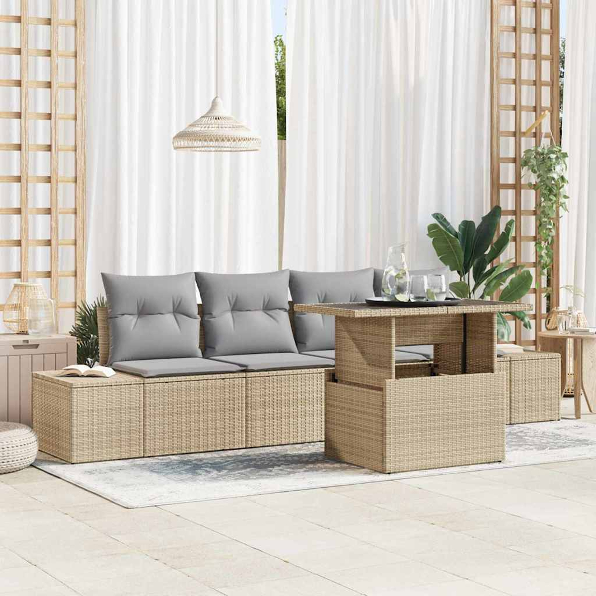 Szene auf der Außenterrasse. Wicker-Sofa mit grauen Kissen, passendem Tisch, weißen Vorhängen und Hängelampe. Pflanzen und Dekoration sind sichtbar.