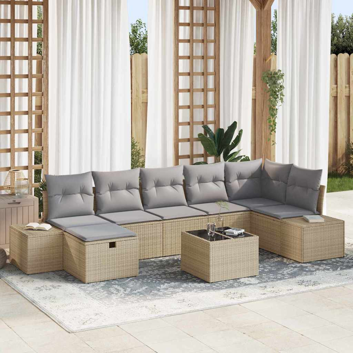 Outdoor-Ecksofa mit grauen Kissen und einem kleinen quadratischen Tisch, auf einem gemusterten Teppich, mit weißen Vorhängen im Hintergrund.