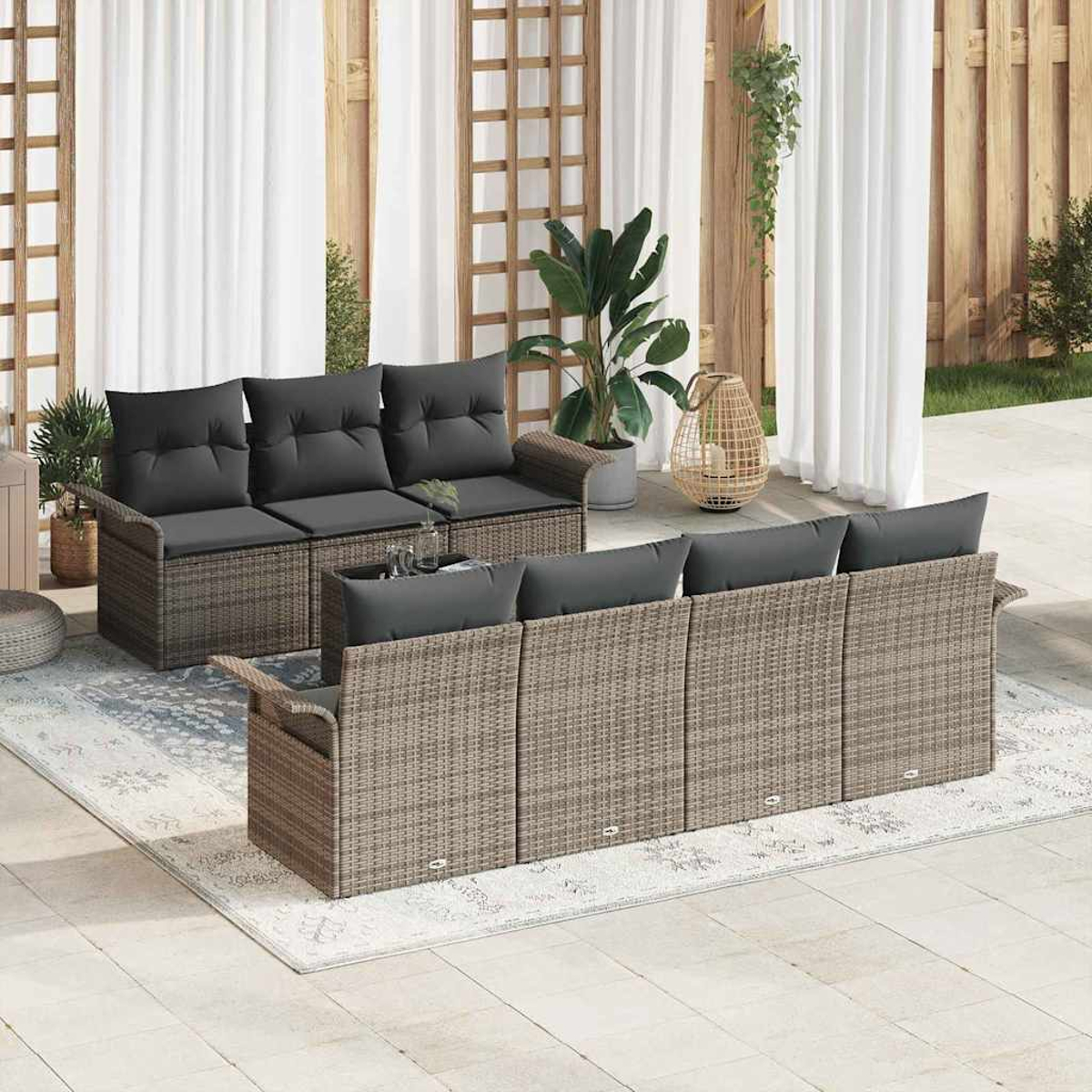 Szene im Freien mit Rattansofas, grauen Kissen, Pflanzen und weißen Vorhängen. Ein Teppich und ein hölzerner Gitterhintergrund verbessern die Umgebung.