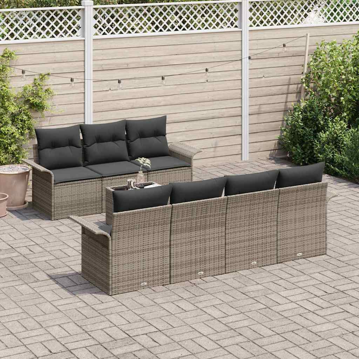 Terrassen-Set im Freien. Zwei Korbs Sofas mit schwarzen Kissen. Holzzaun im Hintergrund. Gepflasterte Terrasse.