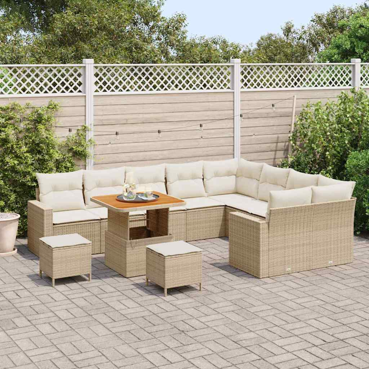 Garten-Terrassenmöbel mit beigem Korbmöbeln, cremefarbenen Kissen und einem Holztisch. Enthält ein Ecksofa, zwei Hocker und einen Zaun.