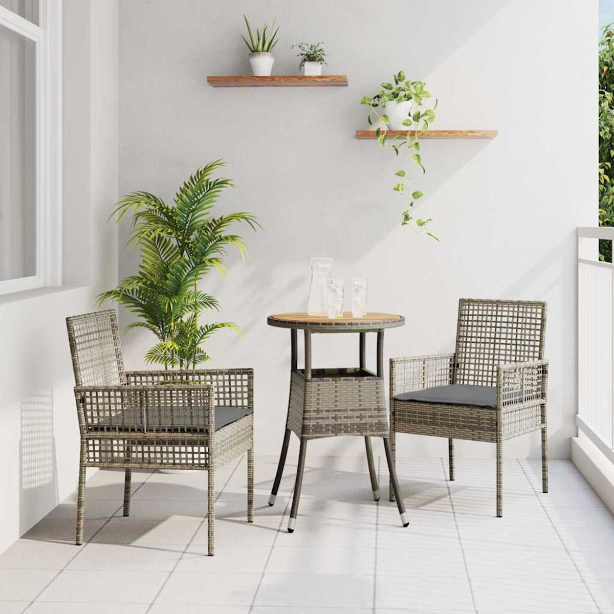 Balkon mit zwei Stühlen, einem kleinen Tisch und Pflanzen. Die Stühle haben graue Kissen. Der Tisch hat eine Holzplatte. Weiße Wände.