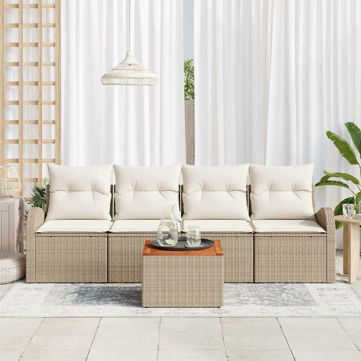 Escena exterior con sofá de mimbre, cojines crema, mesa de centro con bebidas, cortinas blancas y lámpara colgante.