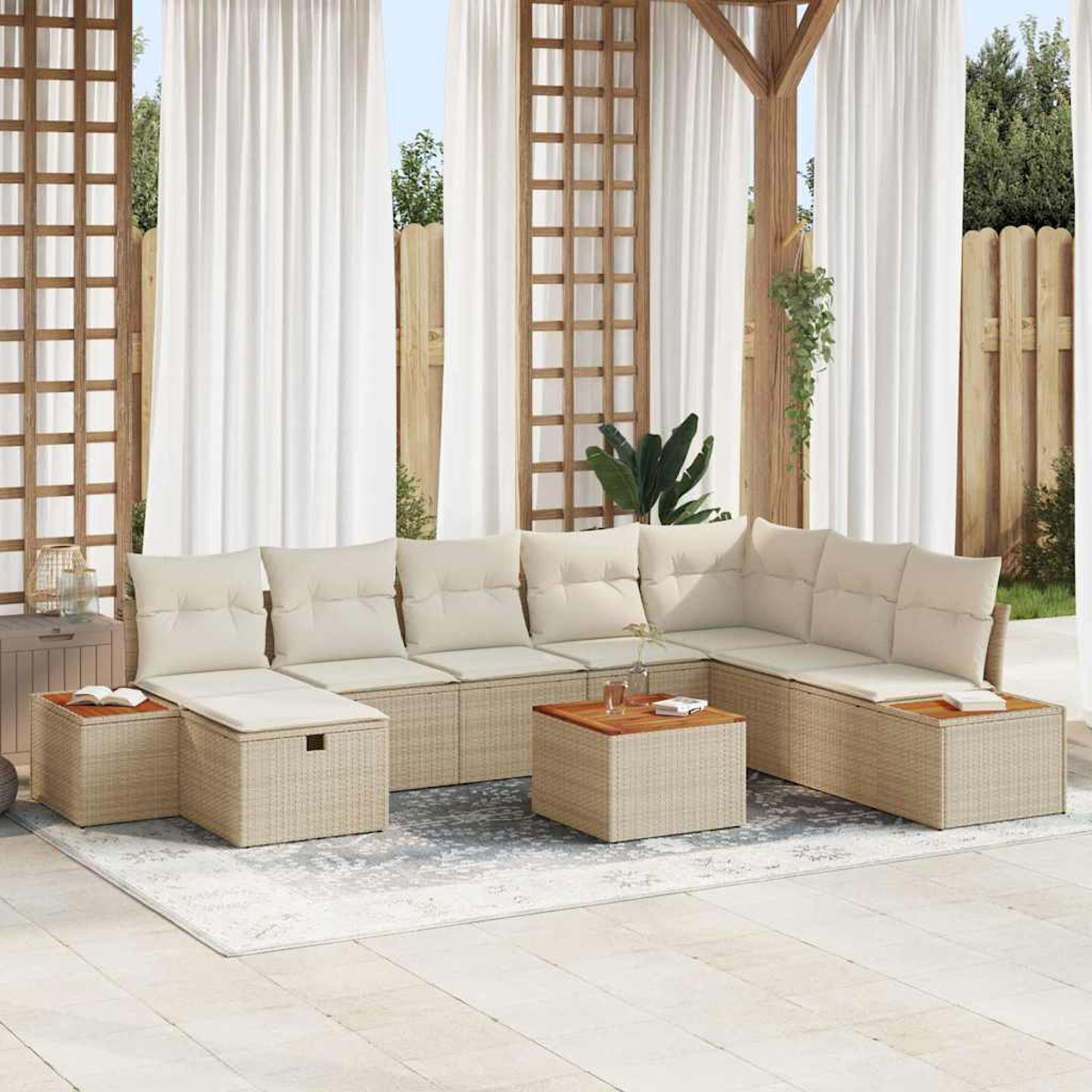 Sofá seccional de ratán beige para exteriores con cojines blancos. Pérgola de madera, cortinas blancas y valla de madera al fondo.