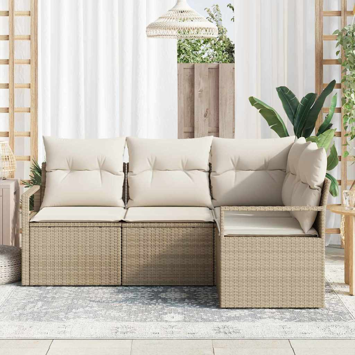 Ein beigefarbenes Korbsesselsofa mit cremefarbenen Kissen steht auf einem gemusterten Teppich. Im Hintergrund befinden sich ein weißer Vorhang und ein Holzzaun.
