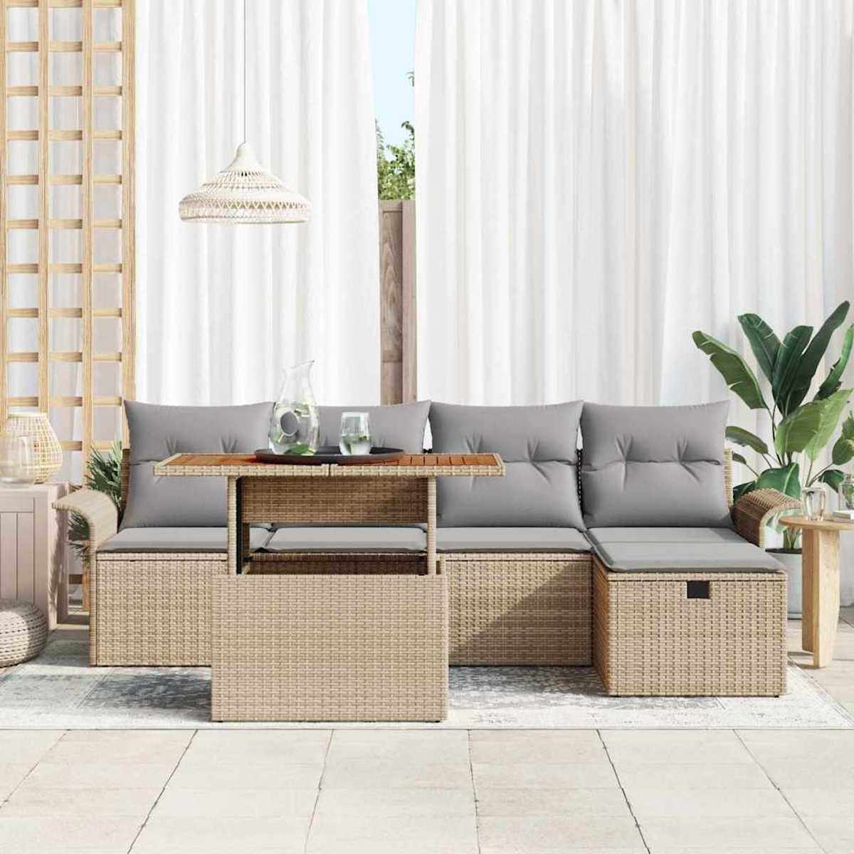 Garten-Sitzgruppe mit grauen Kissen, Tisch mit Wasserglas und weißem Vorhang im Hintergrund mit einer Pflanze.