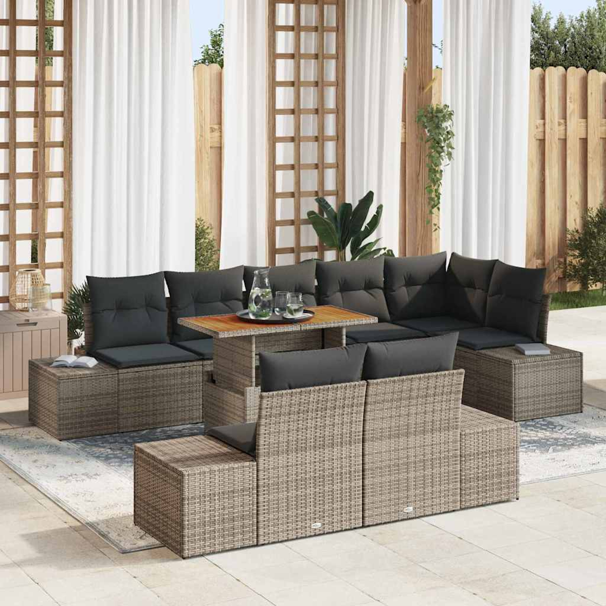 Outdoor-Ecksofa mit grauen Kissen und einem Holztisch, vor weißen Vorhängen und einem Holzzaun.