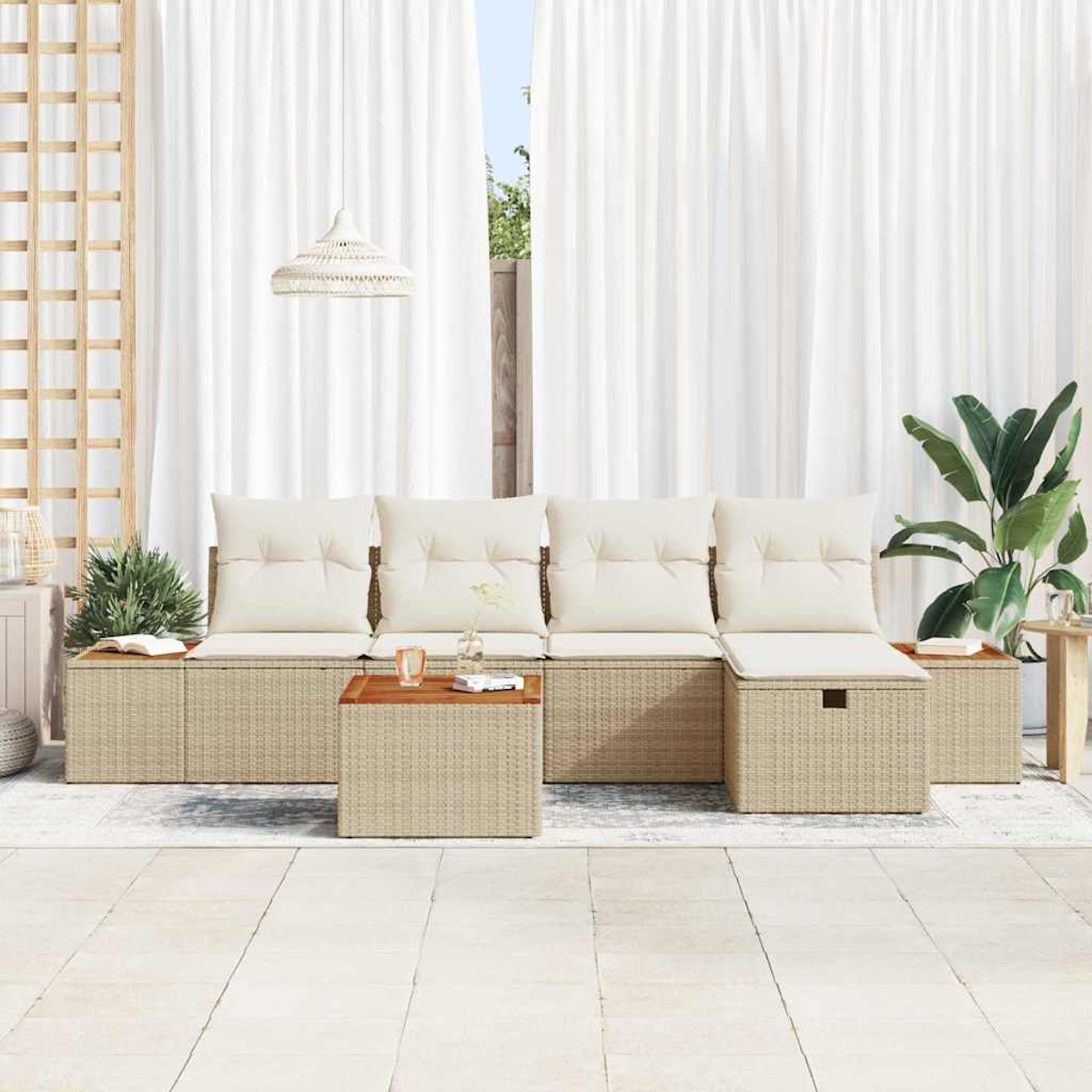 Outdoor-Sitzbereich mit beigen Korbmöbeln, weißen Kissen und einem Holztisch. Weiße Vorhänge im Hintergrund, eine Pflanze rechts.