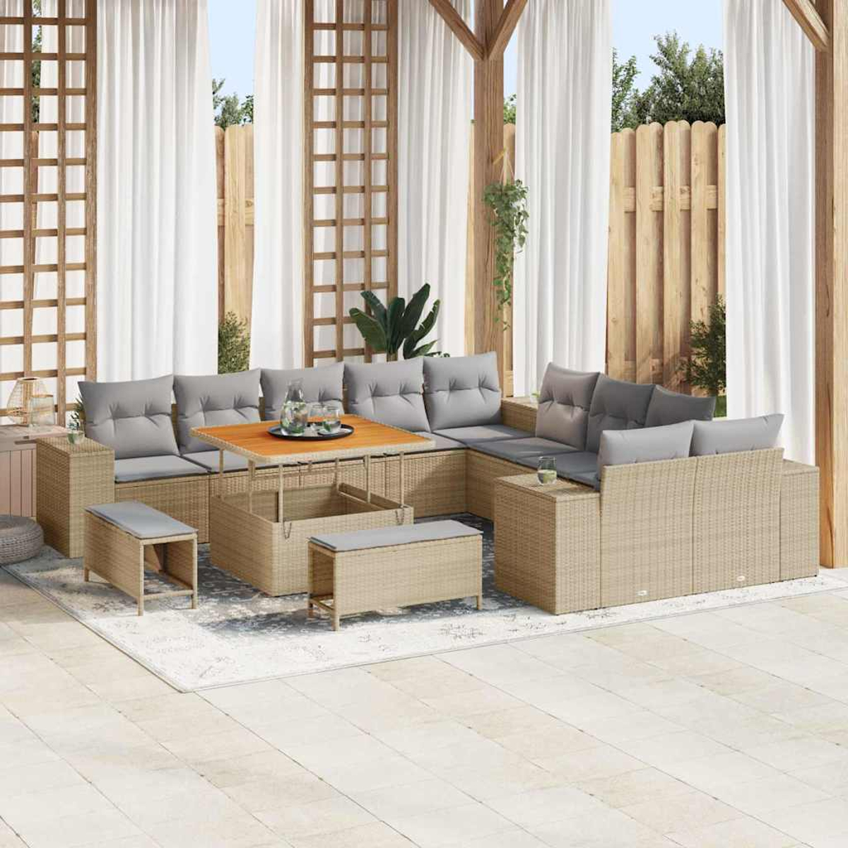 Outdoor-Ecksofa mit grauen Kissen, einem Holztisch und Bänken. Weiße Vorhänge und ein Holzzaun befinden sich im Hintergrund.