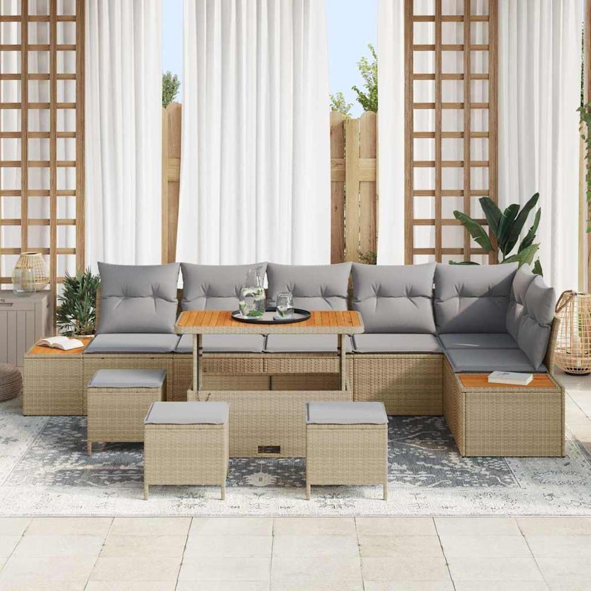 Outdoor-Sofa aus Korbgeflecht mit grauen Kissen, einem Holztisch und Hockern. Weiße Vorhänge und ein Gitter im Hintergrund.