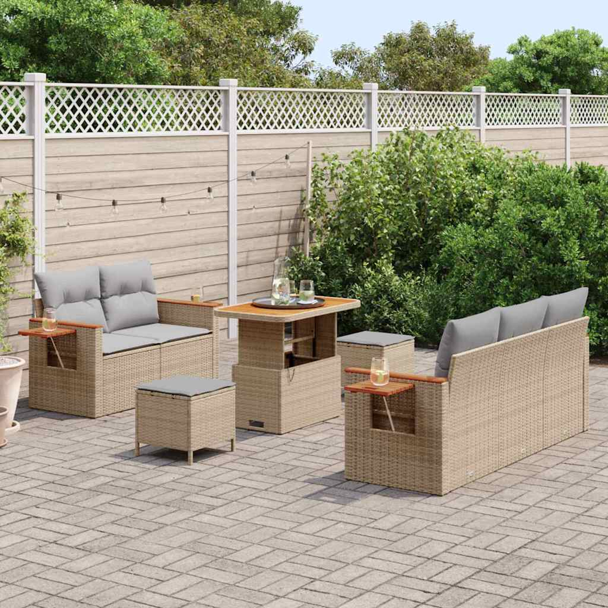 Garten-Sitzgruppe auf einer Terrasse. Enthält ein Liebesnest, ein Sofa, zwei Ottomanen und einen Tisch. Ein Holzzaun und Grünzeug sind im Hintergrund.