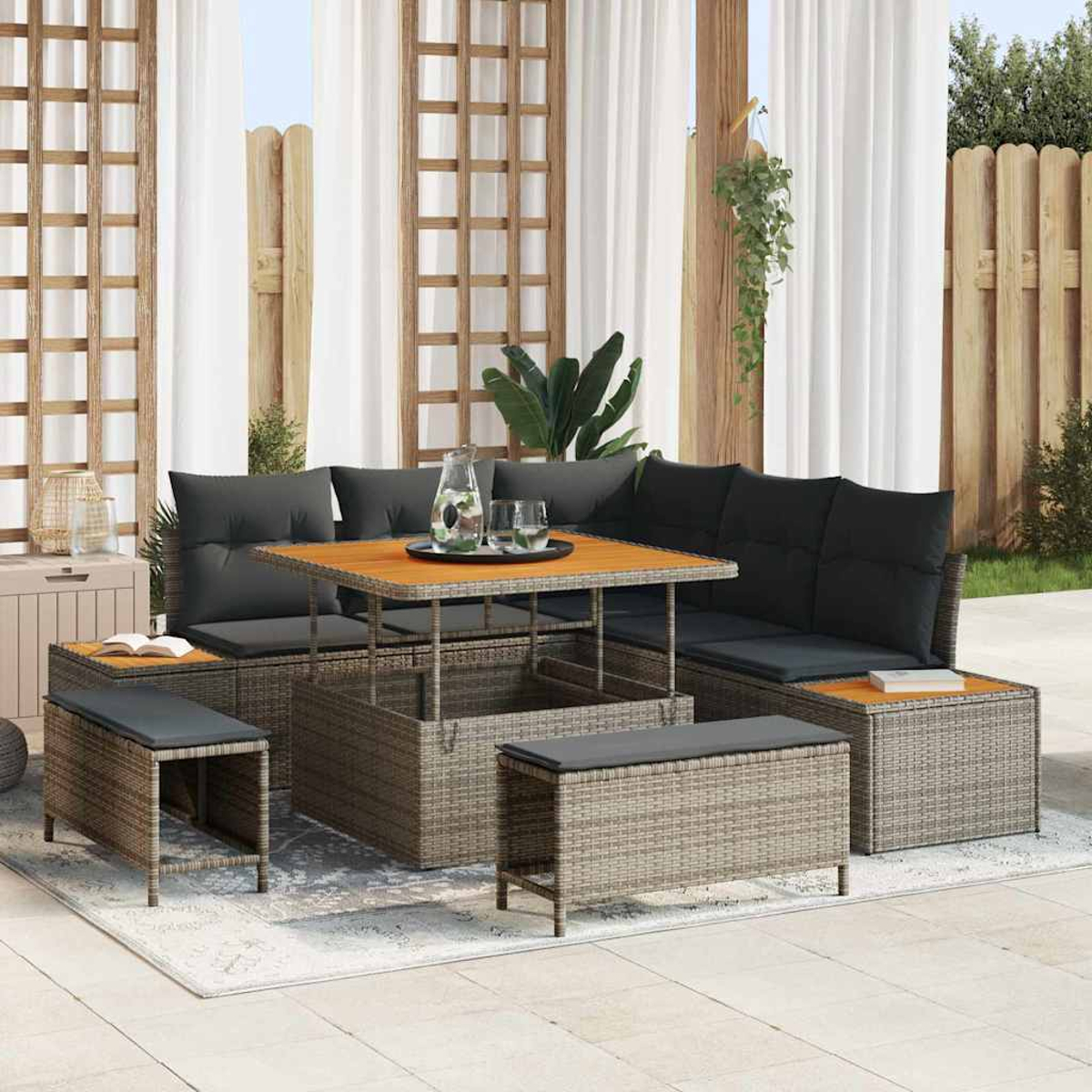 Outdoor-Wicker-Ecksofa mit Hubtisch, Bänken und Kissen. Auf einem gemusterten Teppich, in der Nähe eines Holzzauns.