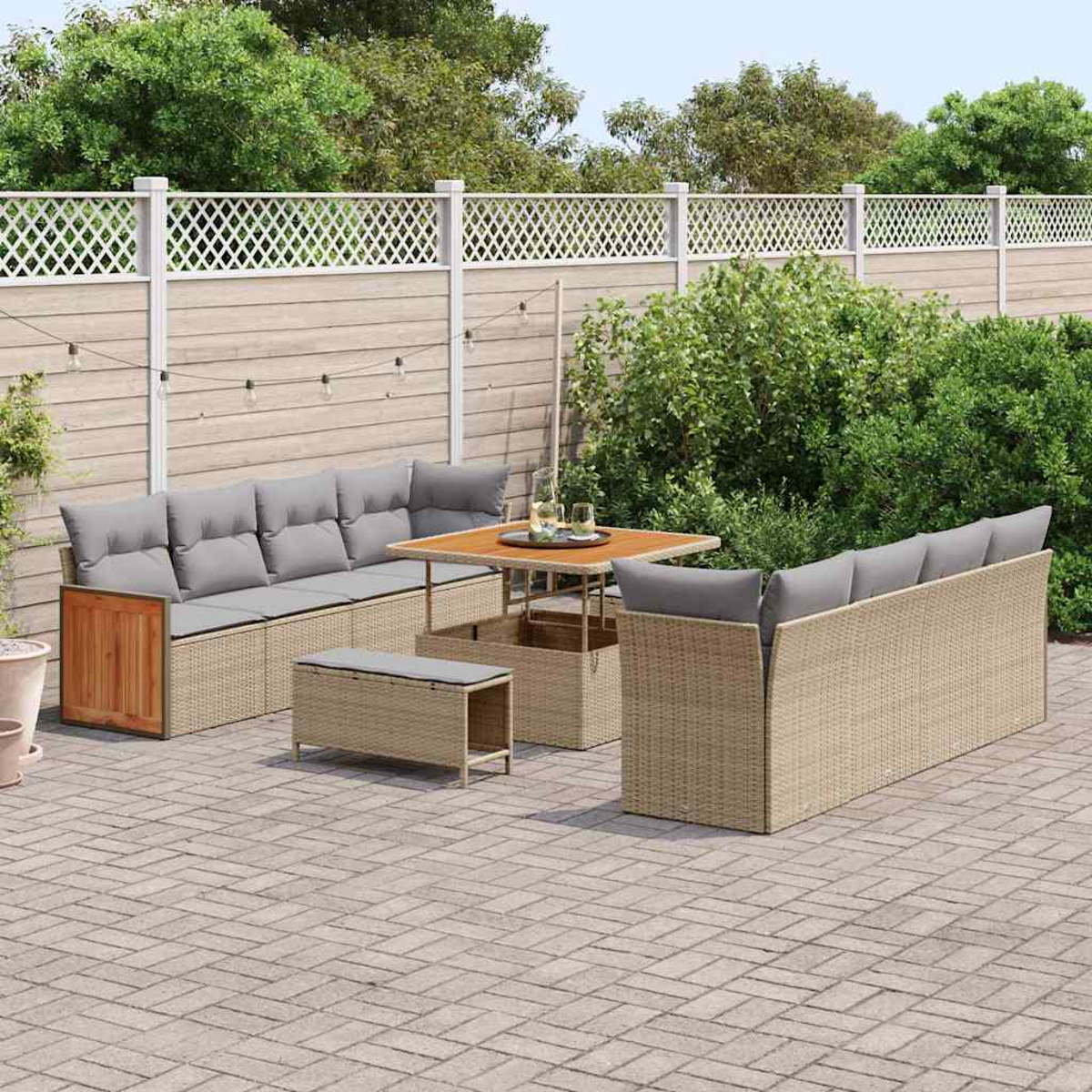 Gartenmöbel-Set. Sofa, Tisch und Bank in neutralen Tönen, auf einem gemusterten Ziegelboden, mit weißem Zaun.